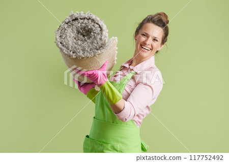 happy woman in green apron and rubber gloves on green 117752492