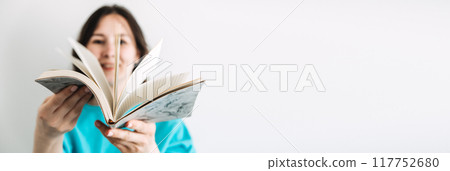 Woman smiling while holding an open book, symbolizing education, empowerment, and gender equality. Woman smiling while holding an open book, symbolizing education, empowerment, and gender equality. 117752680