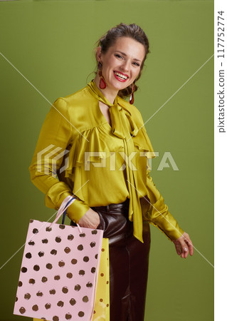 happy fit female in green blouse against green background happy fit female in green blouse against green background 117752774