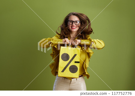 smiling woman in green blouse and glasses against green smiling woman in green blouse and glasses against green 117752776
