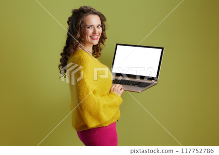 smiling woman showing laptop blank screen isolated on green smiling woman showing laptop blank screen isolated on green 117752786