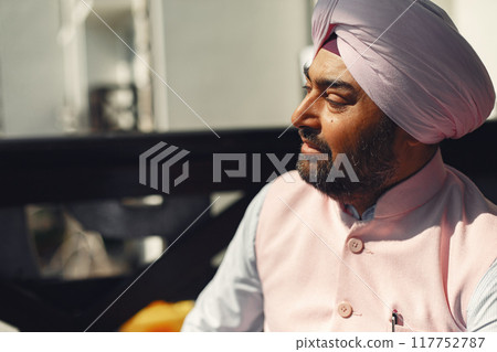 Indian man in a room. Male in a traditional turban. Hinduist in a room. 117752787