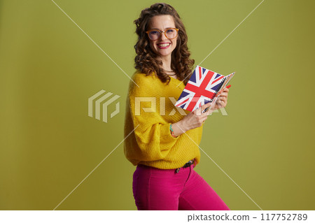 smiling woman in sweater and glasses isolated on green 117752789
