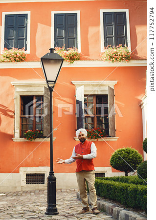 Indian man in a city. Male in a traditional turban. Hinduist in a summer city. 117752794