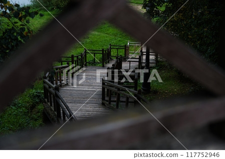 Wooden bridge greenery. Wooden stairs down to the river. Framing 117752946