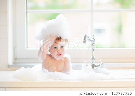 Baby taking bath in kitchen sink Baby taking bath in kitchen sink 117753759