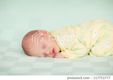 Little baby on white bed 117753777