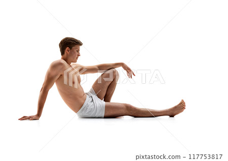 Shirtless man in white boxers kneels with arms extended, striking powerful, athletic pose that highlights his muscular build. Shirtless man in white boxers kneels with arms extended, striking powerful, athletic pose that highlights his muscular build. 117753817