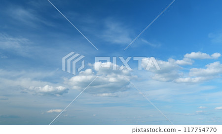 Flying moving white clouds in a blue sky. Blue sky background with many layers tiny clouds. Timelapse. 117754770