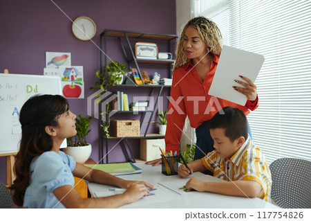 Teacher Guiding Students in Creative Classroom Setting 117754826