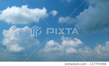 White cumulonimbus fluffy clouds blue sky moving background. Moving and changing cloudscape weather. Timelapse. 117754998