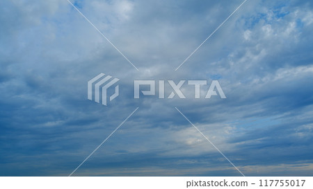 Background of clouds and sky on a sunny day. Light blue and white colours of real skies with clouds. Timelapse. 117755017