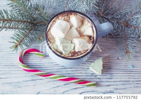 Cups of hot chocolate with marshmallows, tree branches and Christmas decoration on a wooden background.  117755792