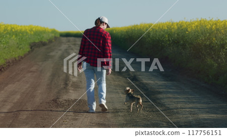 Pretty Farmer Woman Going Through Countryside Enjoying Freedom And Beautiful Summer Environment At Sunset. Farmer Girl Walks Through Field Of Vegetables At Sunset. 117756151