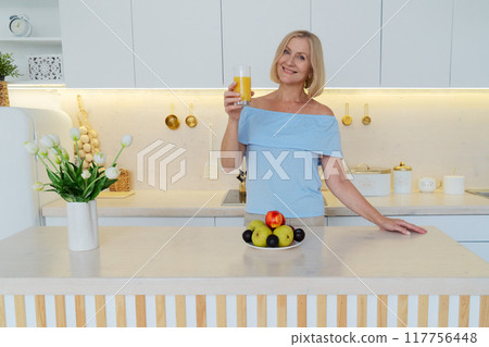 Healthy Lifestyle A Woman Delightfully Enjoying a Refreshing Beverage in a Modern and Stylish Kitchen Space Healthy Lifestyle A Woman Delightfully Enjoying a Refreshing Beverage in a Modern and Stylish Kitchen Space 117756448