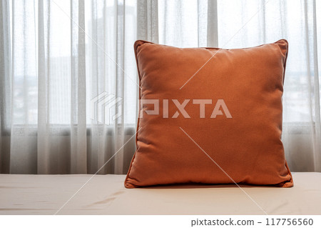 Comfortable bedroom with plush sofa and soft pillow, against a curtain backdrop for rest and relaxation Comfortable bedroom with plush sofa and soft pillow, against a curtain backdrop for rest and relaxation 117756560