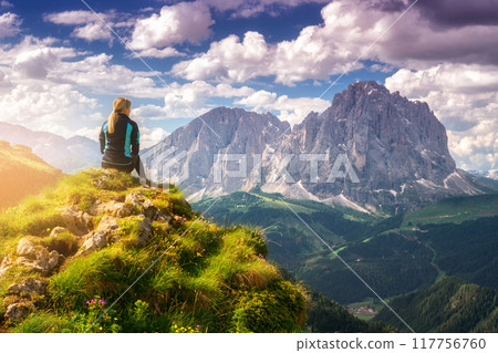 Sitting girl on the peak in beautiful alpine mountain valley Sitting girl on the peak in beautiful alpine mountain valley 117756760
