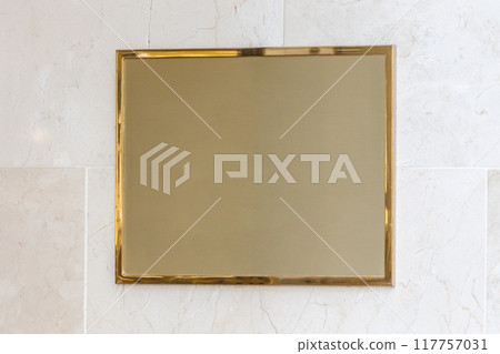 Empty golden frame and plaque on marble wall for your design Empty golden frame and plaque on marble wall for your design 117757031