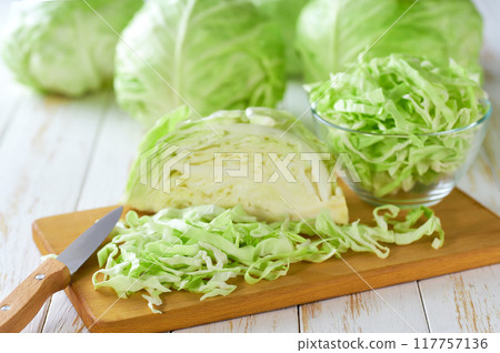 Whole and shredded cabbage on light wooden table. Whole and shredded cabbage on light wooden table. 117757136