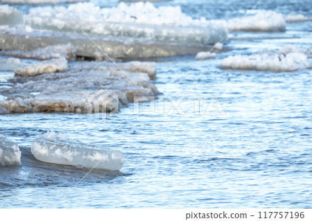 Fragments of melting ice mixed with sand floating on Baltic Sea Fragments of melting ice mixed with sand floating on Baltic Sea 117757196
