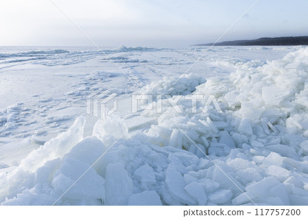 Winter landscape with frozen sea coast and ice hummocks 117757200