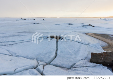 Landscape with frozen Baltic sea at sunset. Cracked ice 117757204