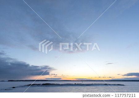 Winter landscape with sunset sky above frozen Baltic sea 117757211