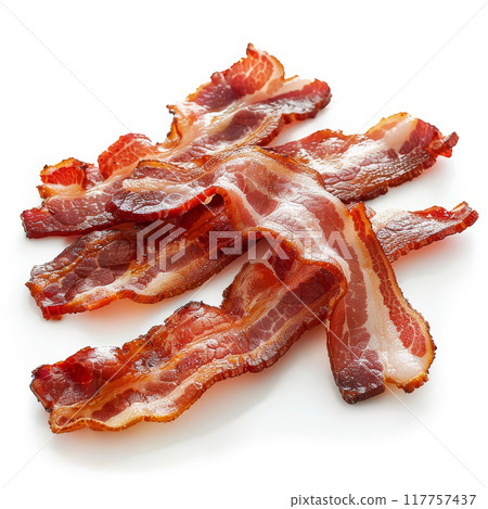 Several slices of cured bacon in a pile on a white background. The bacon slices are thin, translucent and pink with streaks of white marbling. 117757437