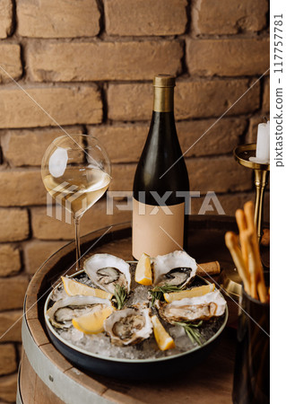 Elegant oysters on ice with lemon and white wine, perfect for gourmet dining and special occasions Elegant oysters on ice with lemon and white wine, perfect for gourmet dining and special occasions 117757781