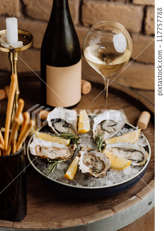 Elegant oysters on ice with lemon and white wine, perfect for gourmet dining and special occasions 117757788