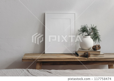 Christmas home decor. Blank greeting card, invitation stationery mockup. Old wooden console table. Modern vase, vpine tree branches. Paper christmas balls. White wall background. Scandinavian interior 117758474