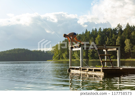 Kids jumping in lake water at summer holiday. Kids jumping in lake water at summer holiday. 117758573