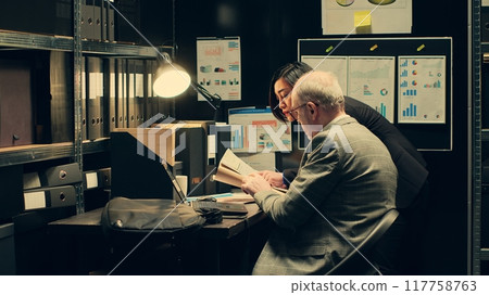 Detectives team search for missing persons or unsolved cases in archived records, looking for connection between investigations. Private agents working with forensic evidence in archive. Camera A. 117758763