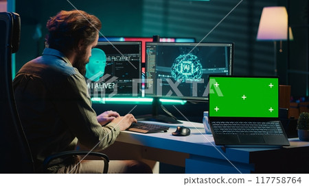 Programmer being asked existential questions by awaken AI gaining consciousness next to chroma key laptop. Man communicating with artificial intelligence through isolated screen device, camera A 117758764