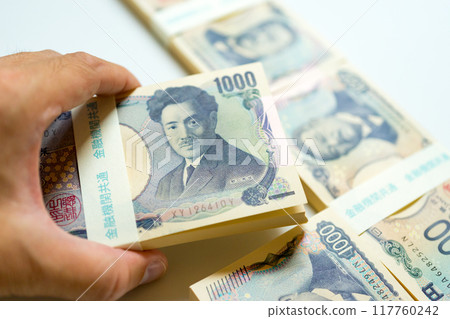 2024: A hand holding a stack of old 1,000 yen bills 2024: A hand holding a stack of old 1,000 yen bills 117760242