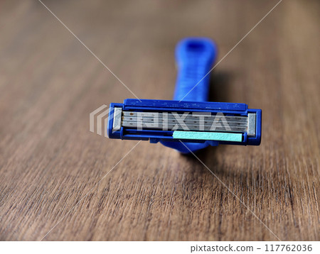 An old and used Razor shaver with a rusty and grunge blade on wooden table 117762036