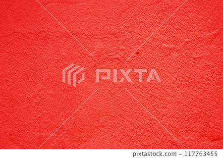 The surface of an old, rough concrete wall is red. 117763455