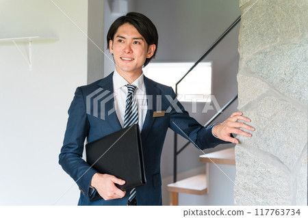 A male advisor/planner for a house builder explains about brick interior wall materials. 117763734