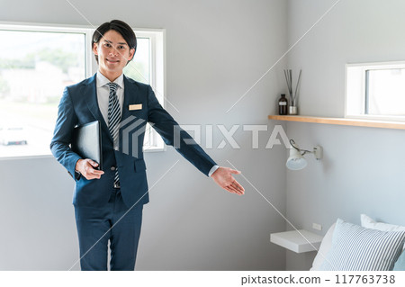 A businessman/hotel man introducing the bedroom A businessman/hotel man introducing the bedroom 117763738