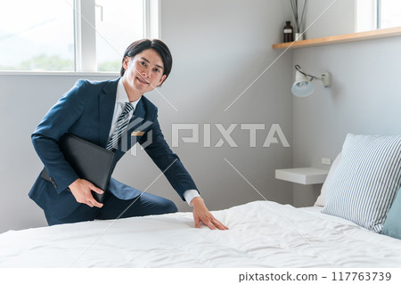A businessman/hotel man introducing the bedroom A businessman/hotel man introducing the bedroom 117763739
