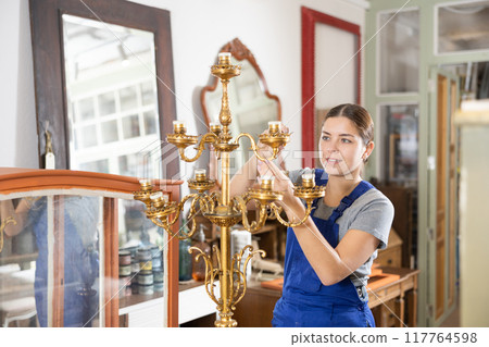 Portrait of skillful repair woman carpenter renovating candlestick furniture using tools in woodwork studio 117764598