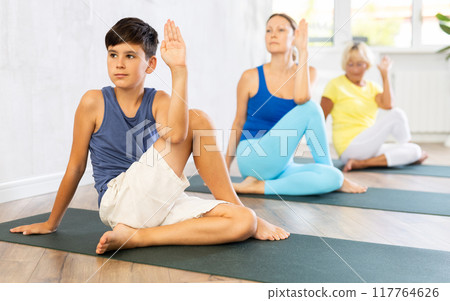 Group of people generation on mats doing yoga exercise lord of fishes pose. Group of people generation on mats doing yoga exercise lord of fishes pose. 117764626