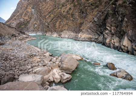 The landscape of Tiger Leaping Gorge in Yunnan province of China. Scenic spot where a tiger is said to have leaped across the river, thus giving the gorge its name. The landscape of Tiger Leaping Gorge in Yunnan province of China. Scenic spot where a tiger is said to have leaped across the river, thus giving the gorge its name. 117764994