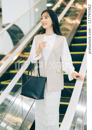 A woman riding an escalator A woman riding an escalator 117765962