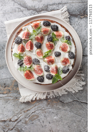 Italian fig and blackberry cake with cream cheese close-up in a plate. Vertical top view 117768515