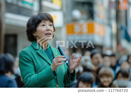 A female politician giving a street speech in a green suit. 117768720