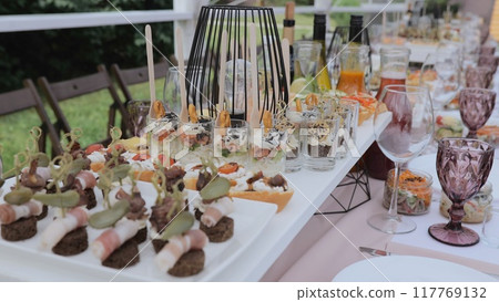 Buffet and snacks at a business event. Beautifully decorated banquet table with appetizers from canapes. Business lunch. Beautiful festive table with appetizers Buffet and snacks at a business event. Beautifully decorated banquet table with appetizers from canapes. Business lunch. Beautiful festive table with appetizers 117769132