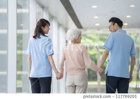 高級婦女和護理人員手牽手行走，後視 117769203