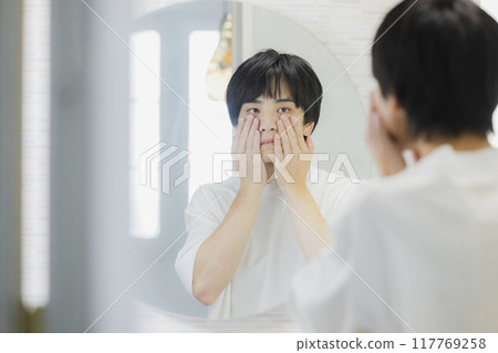 Man doing skin care in the bathroom Man doing skin care in the bathroom 117769258
