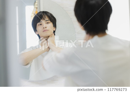 Man doing skin care in the bathroom Man doing skin care in the bathroom 117769273